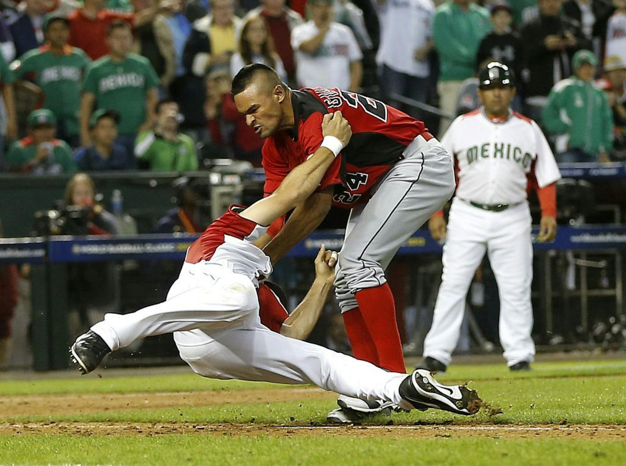 Canada's Tyson Gillies, right and Mexico's Alfredo Aceves fight during the ninth inning of a World Baseball Classic game, Saturday, March 9, 2013, in Phoenix.