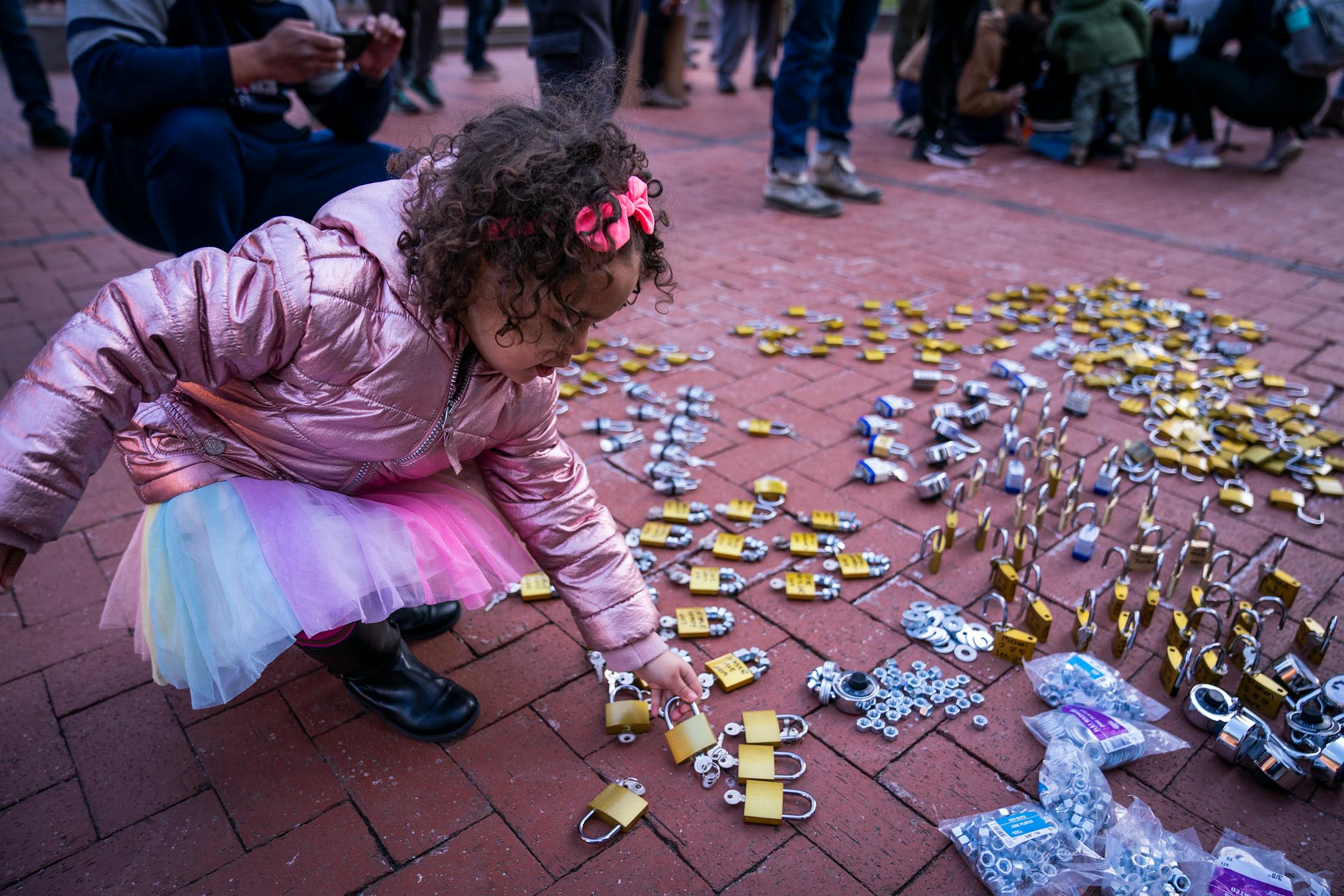 Zeriah Myette, 4, of Elk River picked up some locks to place on the fence outside the Hennepin County Government Center during the Locks for Loved Ones Lost: Part II event.