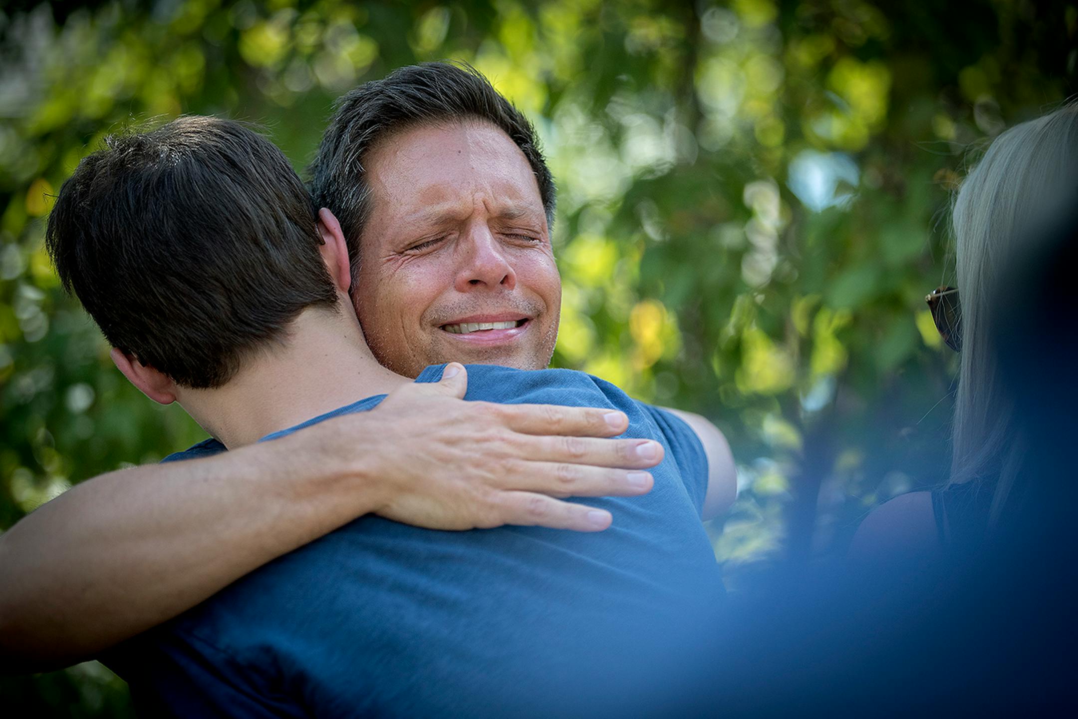 Don Damond is comforted by friends and family after he made a statement to the press near his home after Minneapolis police officer shot and killed his fiance Justine Damond.