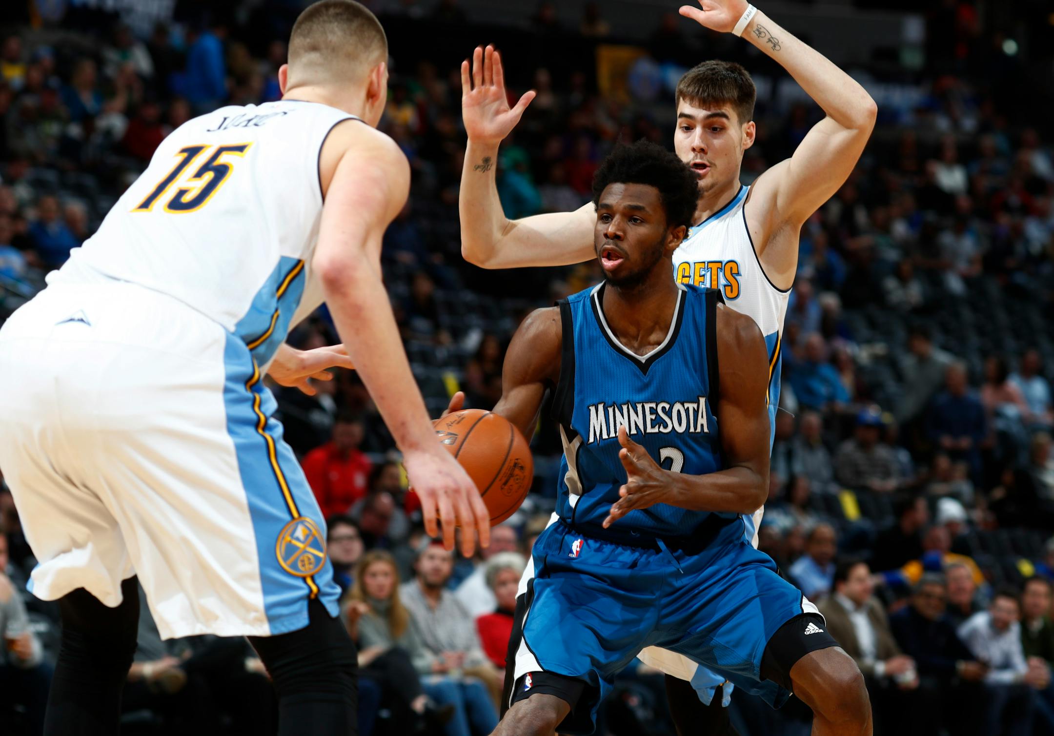 Minnesota Timberwolves forward Andrew Wiggins, center, loses control of the ball as he drives the lane to the rim between Denver Nuggets forwards Nikola Jokic, front, of Serbia, and Juancho Hernangomez, of Spain, in the first half of an NBA basketball game Wednesday, Feb. 15, 2017, in Denver. (AP Photo/David Zalubowski)