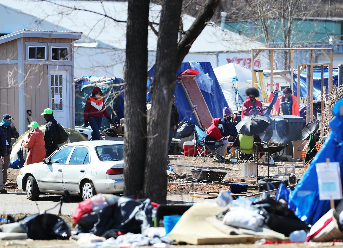 Police scuffled with activists as they moved to clear out a homeless encampment on the Near North side of Minneapolis Thursday morning. For now, the settlement, about two dozen tents, remains. Here, residents sat around a camp fire.