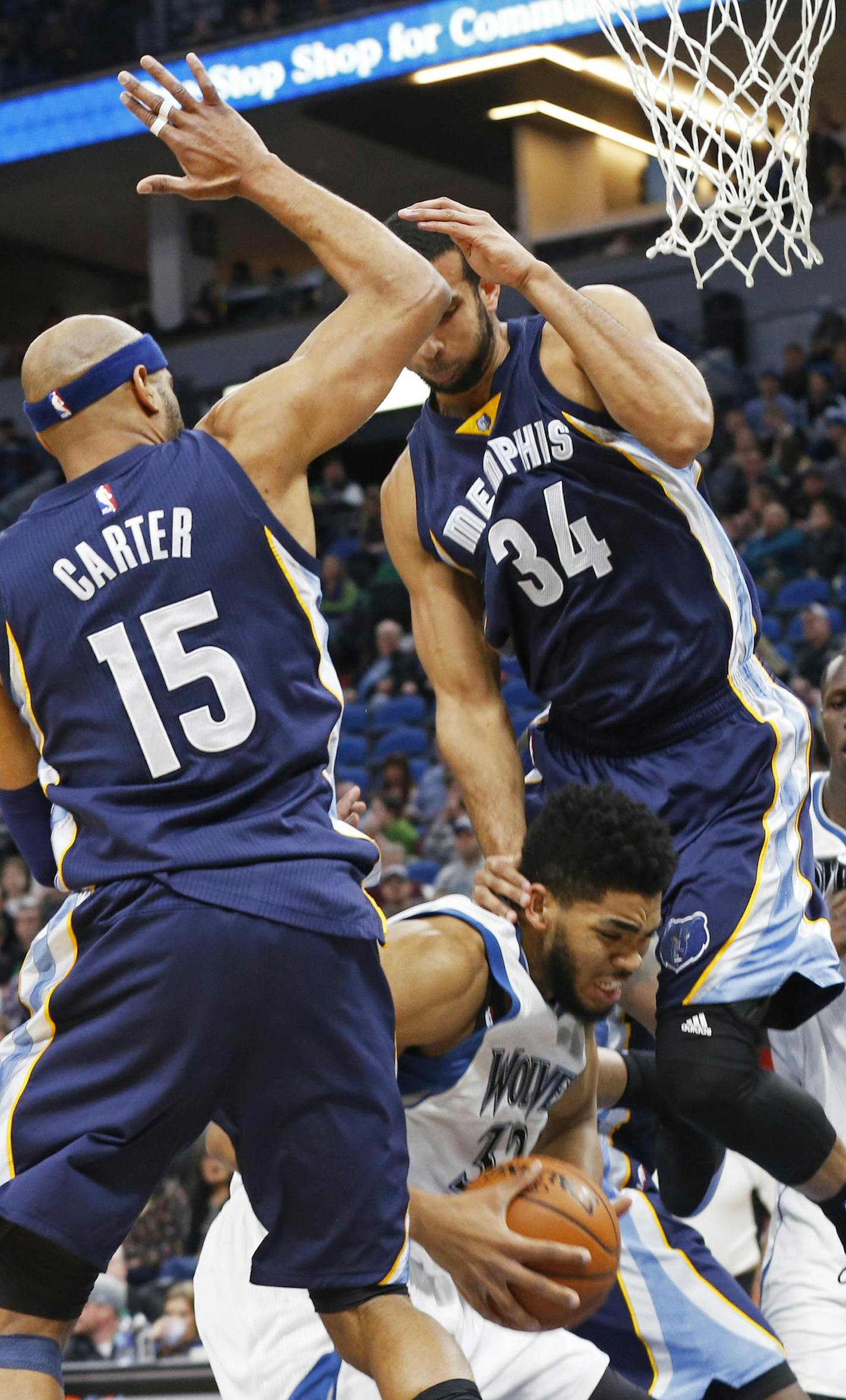 Minnesota Timberwolves' Karl-Anthony Towns, center, gets squeezed between Memphis Grizzlies' Vince Carter, left, and Brandan Wright who fouls him during the first quarter of an NBA basketball game Saturday, Feb. 4, 2017, in Minneapolis. (AP Photo/Jim Mone)