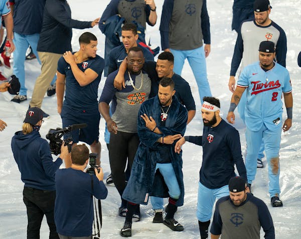 Twins players, including, from left, first baseman Miguel Sano and relief pitcher Jorge Alcala, right, left fielder Eddie Rosario (20), and third base