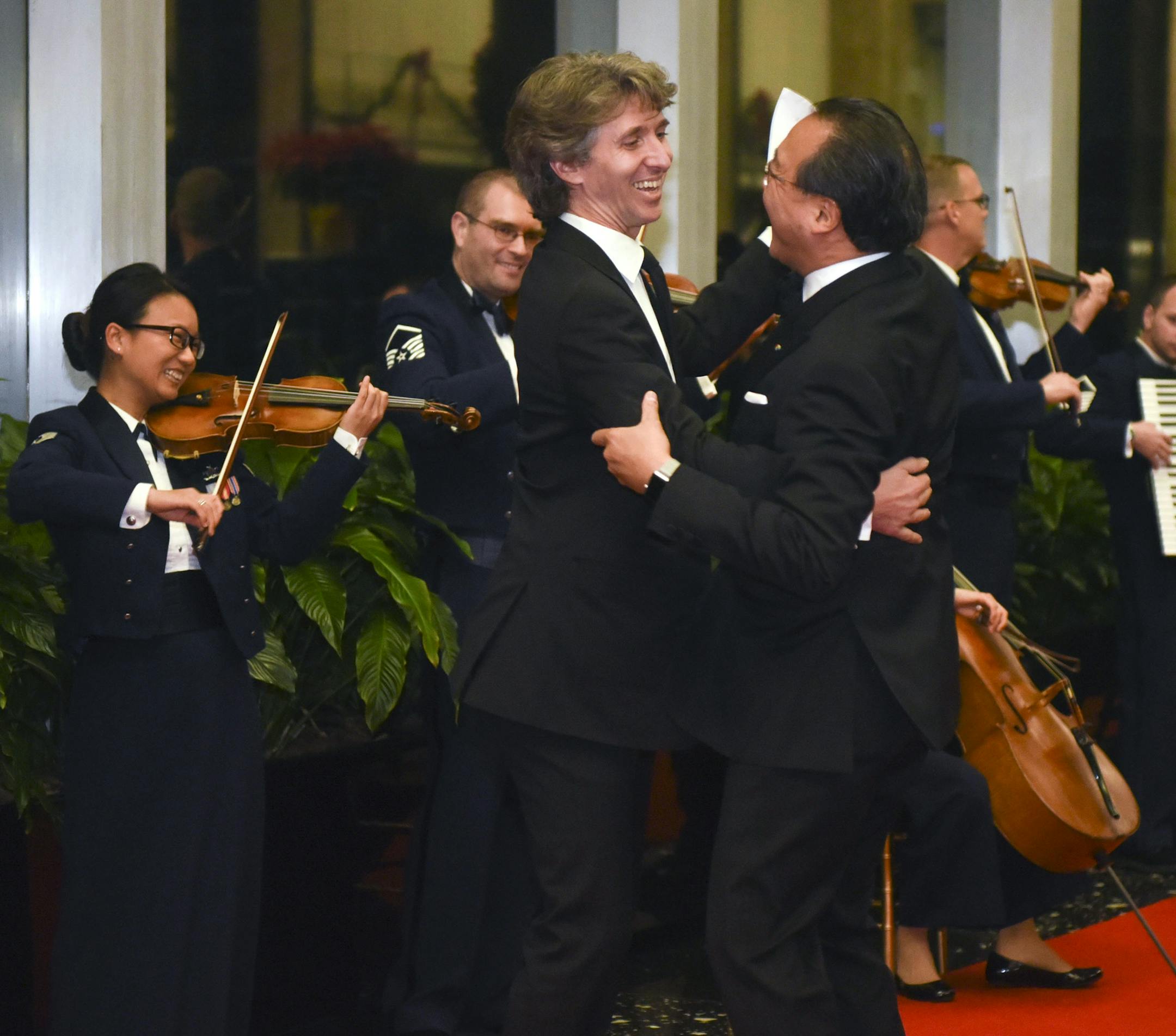 Yo-Yo Ma dances with Damian Woetzel on the red carpet as the Air Force Strolling Strings play at the State Department Dinner for the Kennedy Center Honors on Saturday, Dec. 5, 2015 at the State Department in Washington. (AP Photo/Kevin Wolf)