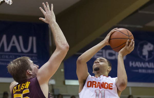 Minnesota center Elliott Eliason (55) attempts to block a shot by Syracuse guard Tyler Ennis (11) during a tournament game in November 2013.