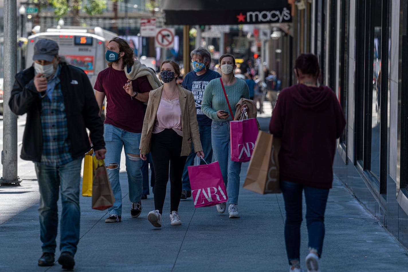 People wearing protective masks carry shopping bags in San Francisco on June 10, 2021. MUST CREDIT: Bloomberg photo by David Paul Morris.