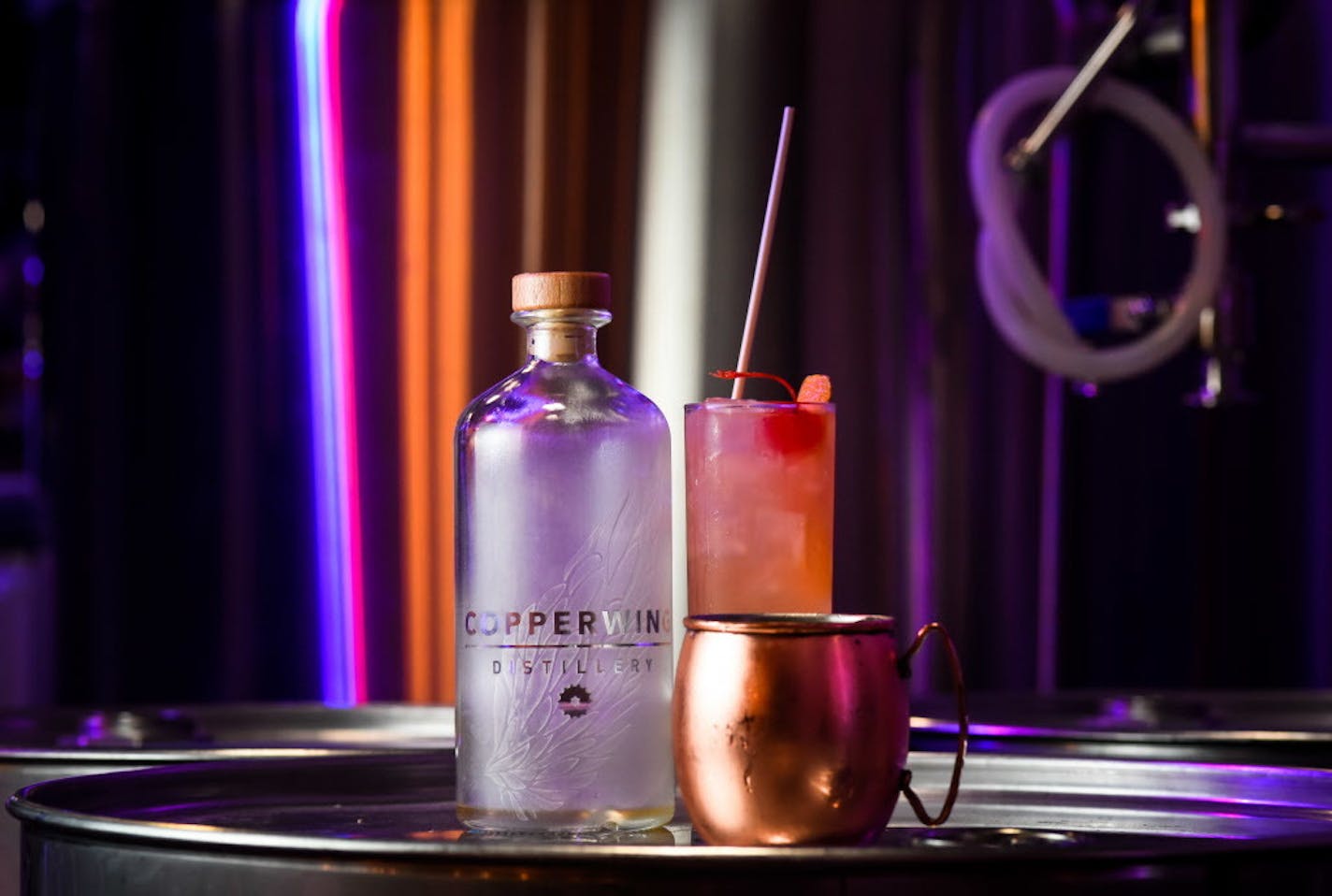 A Vodskey bottle beside a "Copper Mule," made with Vodskey, fresh lime juice and Fever Tree ginger beer, as well as a "Wing in a Sling," back, with Vodskey, Copperwing's sweet orange liqueur, pineapple juice, lime juice and cherry and Jamaican bitters.