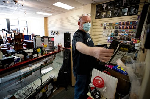 Ted Vig arranged bass strings on the wall at Vig's guitars in St. Paul. Looters trashed the tiny shop and stole instruments and equipment valued at $40,000.