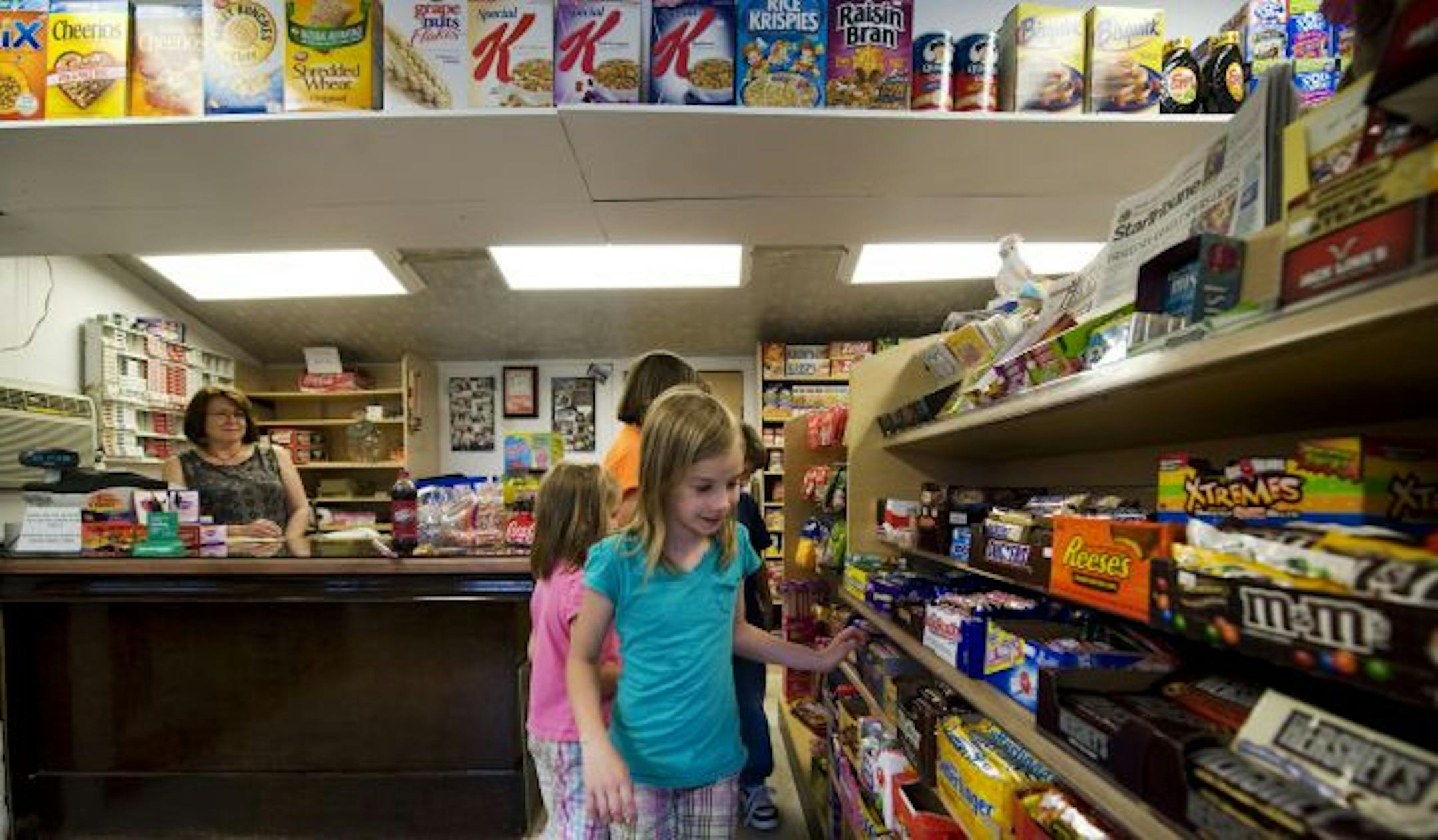 The candy selection drew 8-year-old Ellie Przybilla, front, along with her sisters Monica and Megan and brother John. Toni Jett, left, took over the Coon Rapids store after her mother died.