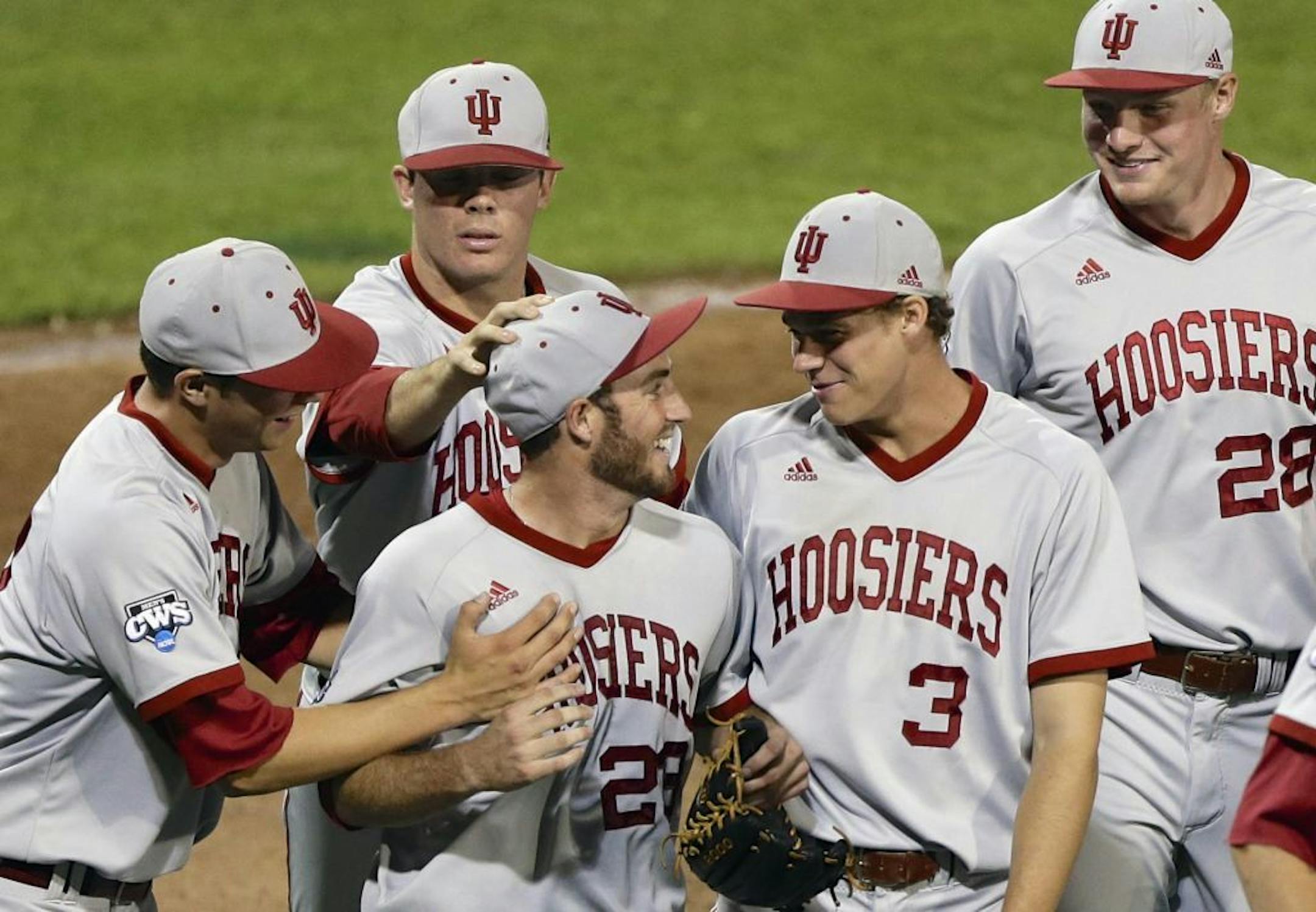 Indiana pitcher Joey DeNato, center, is congratulated by teammates Scott Effross, left, Scott Donley (3) and Luke Harrison (28) after he pitched a complete game against Louisville in an NCAA College World Series game in Omaha, Neb