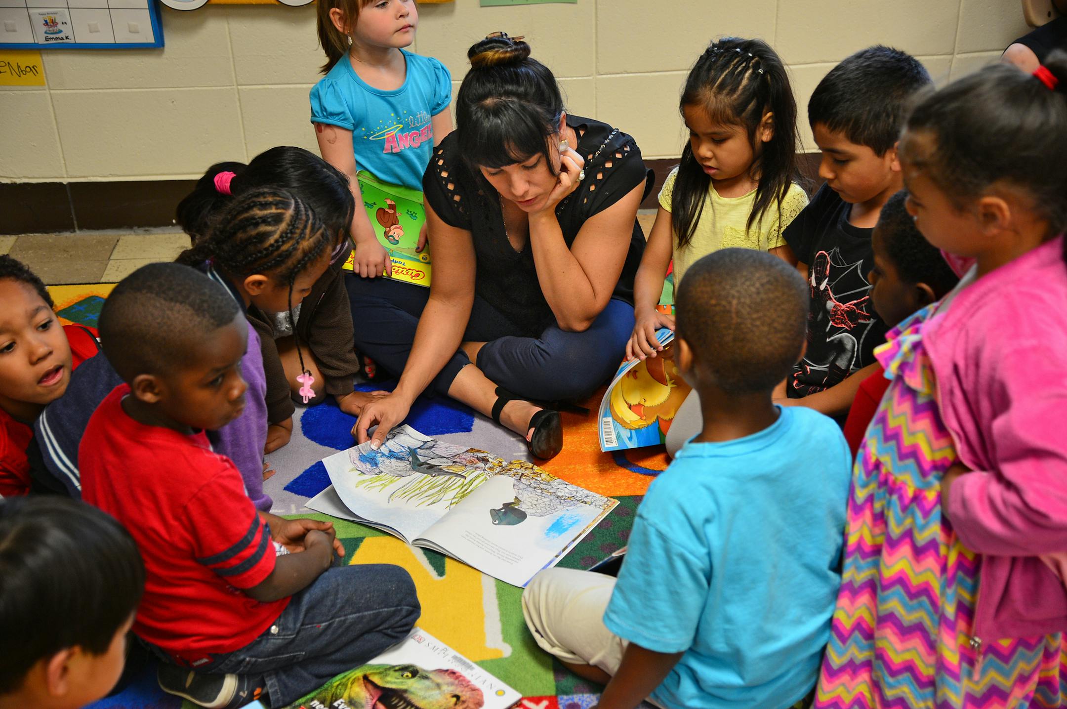 Hannah Campbell reads in a circle to students of the Kinder Prep Plus class in Bloomington at the Pond Family Center. Her son attends the program.