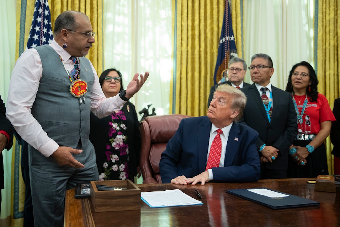 President Donald Trump listens as Kevin DuPuis, chairman of Fond du Lac Band of Lake Superior Chippewa, speaks during an event to sign an executive order establishing the Task Force on Missing and Murdered American Indians and Alaska Natives, in the Oval Office of the White House, Tuesday, Nov. 26, 2019, in Washington.