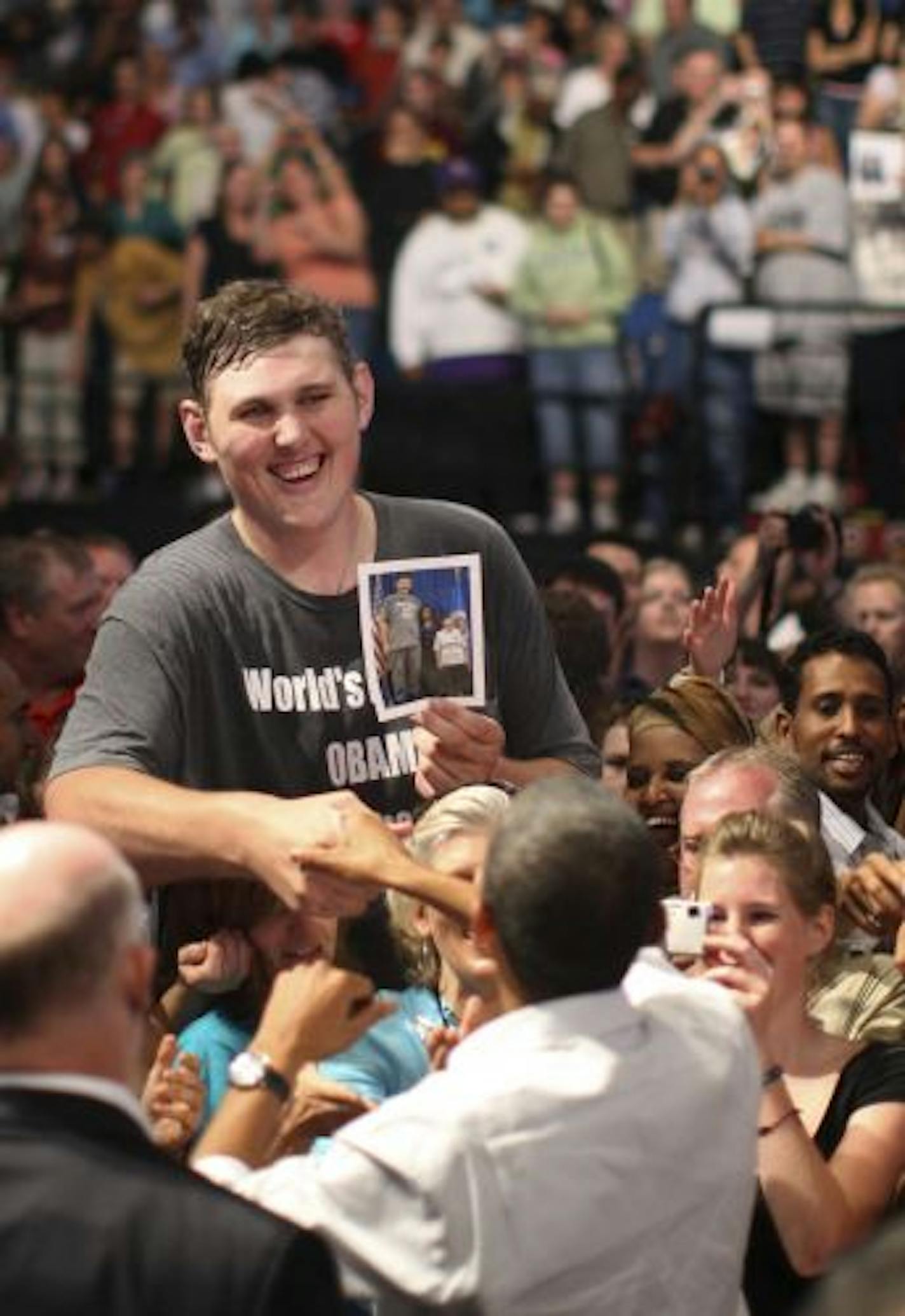 Igor Vovkovinskiy, 27, and 7' 8" tall, shook hands with President Barack Obama while he showed him a photo of himself with Michelle Obama. He was wearing a t-shirt that said "World's Biggest Obama Supporter."