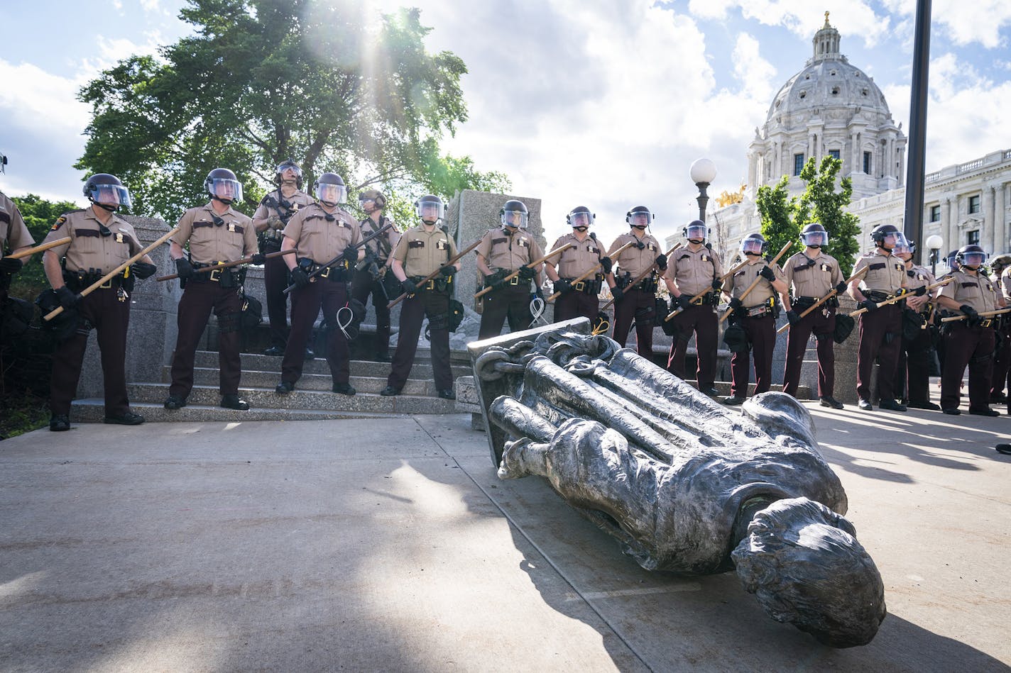 Minnesota State Troopers surround the statue of Christopher Columbus after it was toppled and before it could be hauled away by a tow truck, in front of the Minnesota State Capitol in St. Paul, Minn., on Wednesday, June 10, 2020. (Leila Navidi/Minneapolis Star Tribune/TNS) ORG XMIT: 1687042