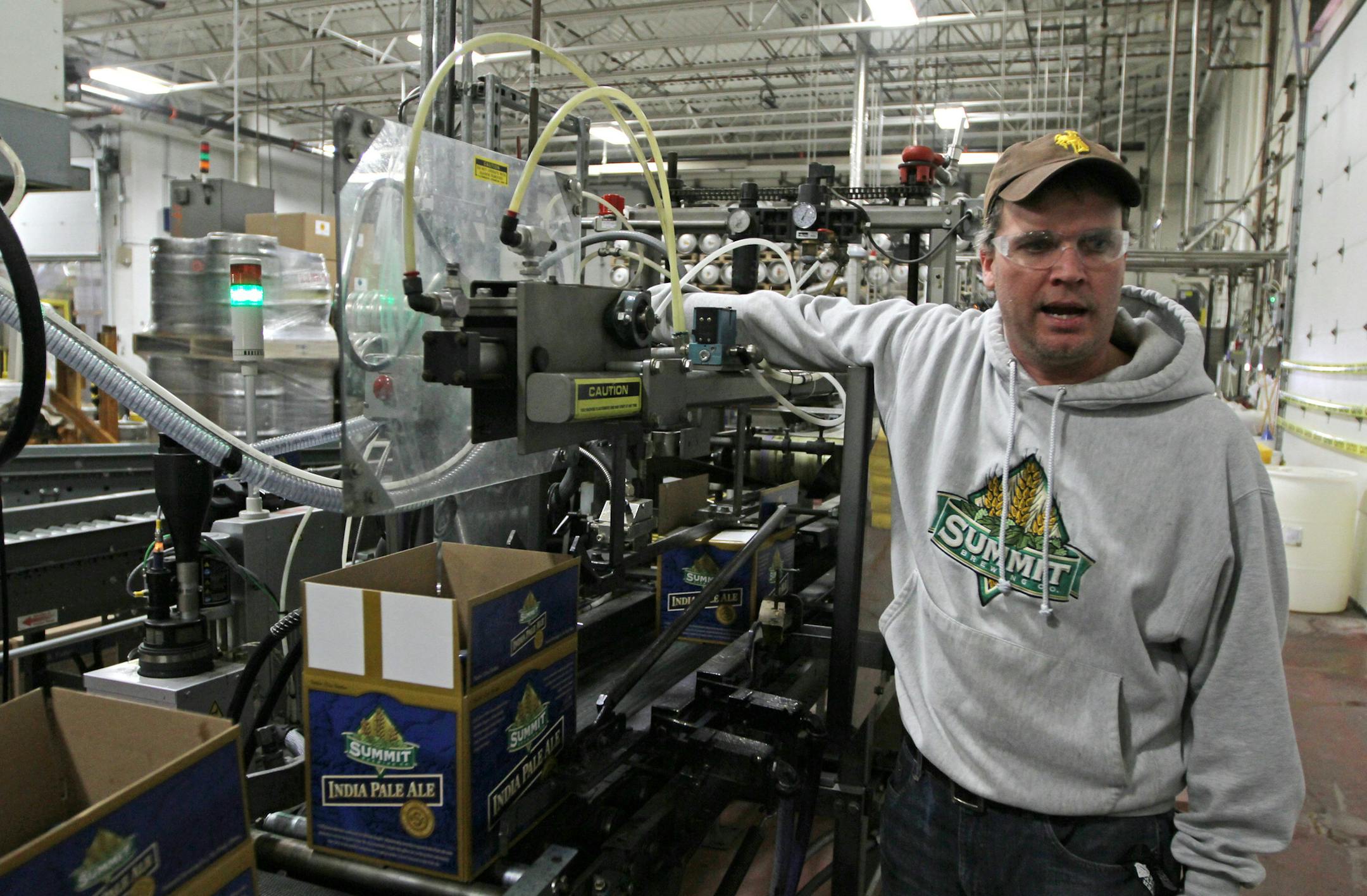 Kenny Gunderman, Summit Brewing Packaging Manager explained how the boxes of Summit beer are glued shut by a Graco glue head as they passed underneath while going down the assembly line. Graco has launched a new line of hot glue equipment that dispenses packaging glue. The new equipment, which applies glue, is a departure for Graco, which is better known for making sprayers that apply paint, powder, insulation and lubricants. Bruce Bisping/Star Tribune bbisping@startribune.com Kenny Gunderman/so