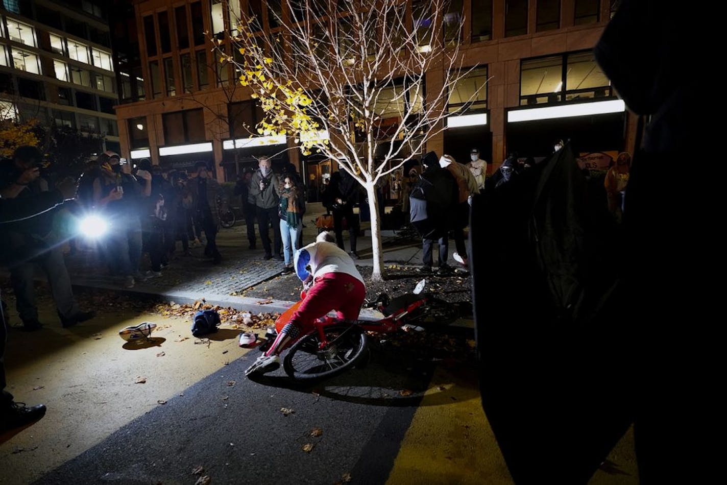 A supporter of President Donald Trump gets up after water was poured on him Saturday, Nov. 14, 2020, in Washington. The man sprayed a substance at people who were surrounding him prior to the fall.