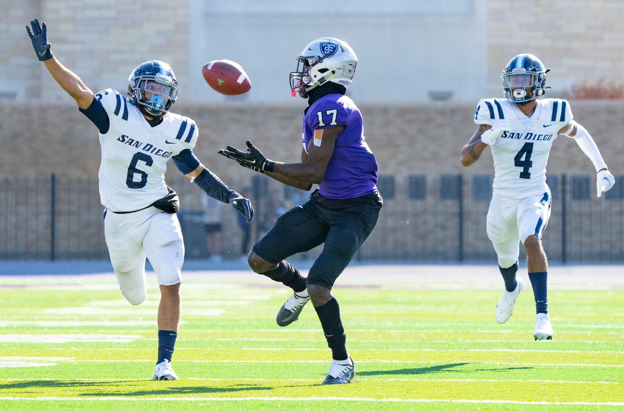 St. Thomas wide receiver Andrew McElroy (17) catches a 57-yard touchdown pass in front of San Diego Toreros safety Hunter Nichols (6) and cornerback Zamir Wallace (4).