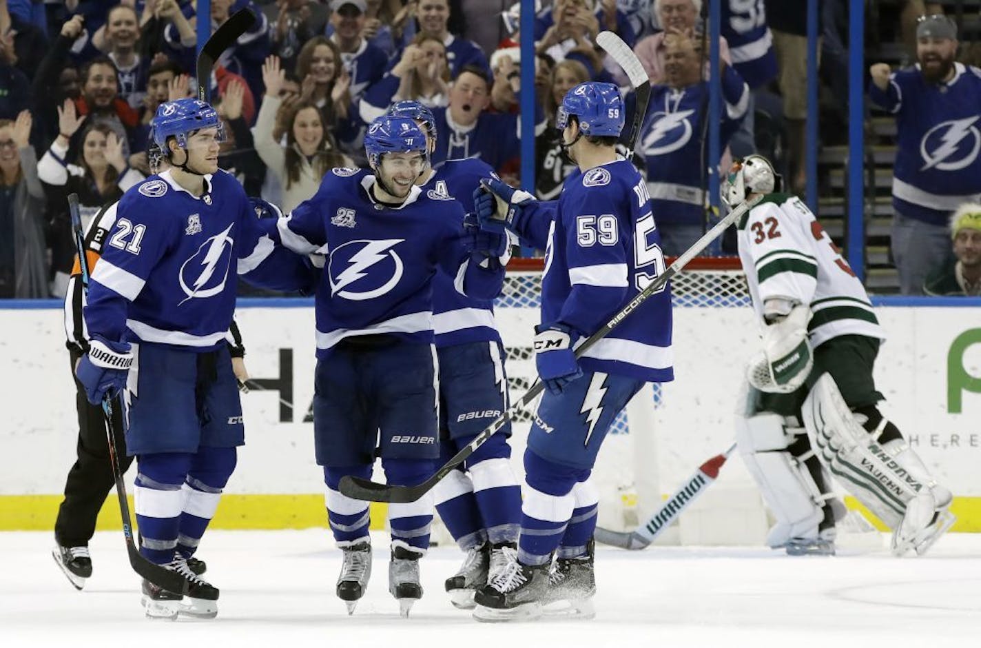 Tampa Bay Lightning center Tyler Johnson (9) celebrates his goal against the Minnesota Wild with defenseman Jake Dotchin (59) and center Brayden Point (21) during the third period of an NHL hockey game Saturday, Dec. 23, 2017, in Tampa, Fla. The Lightning won 3-0.