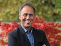 photo of author Anthony Horowitz, with flowers in the background