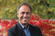 photo of author Anthony Horowitz, with flowers in the background