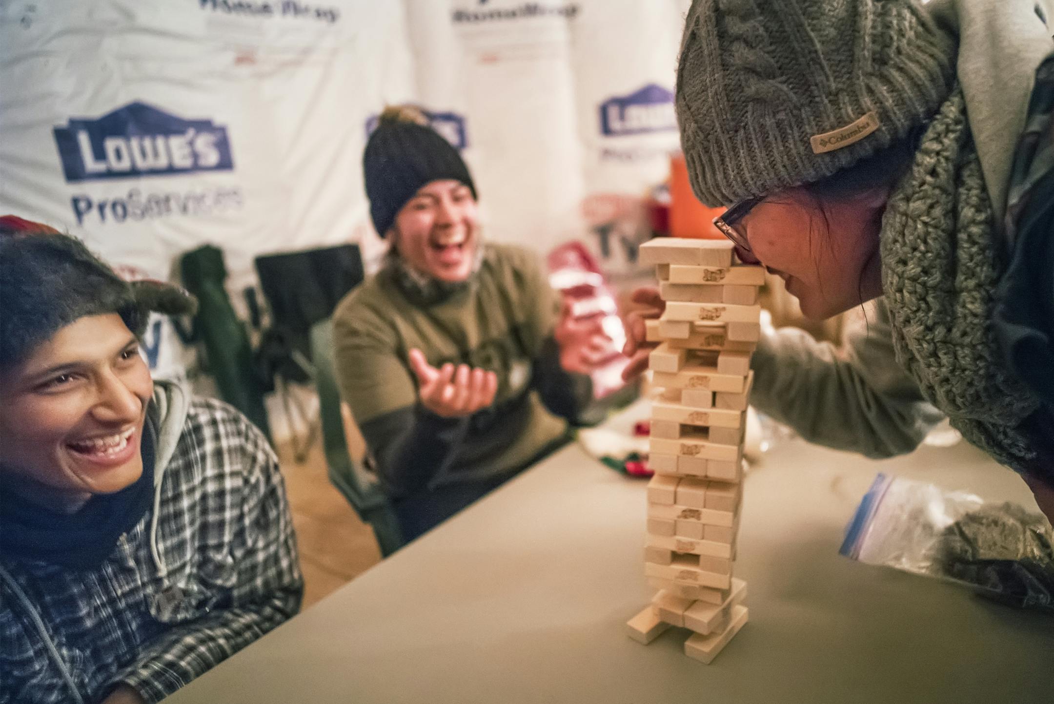 Northern Cheyenne member Talon Lonebear and his fiancee JoRee LaFrance, a Crow Agency member watched as AJ Taptto, a Navajo, tried to save her precarious Jenga tower from collapsing on Thursday, Dec. 1 at Oceti Sakowin camp.