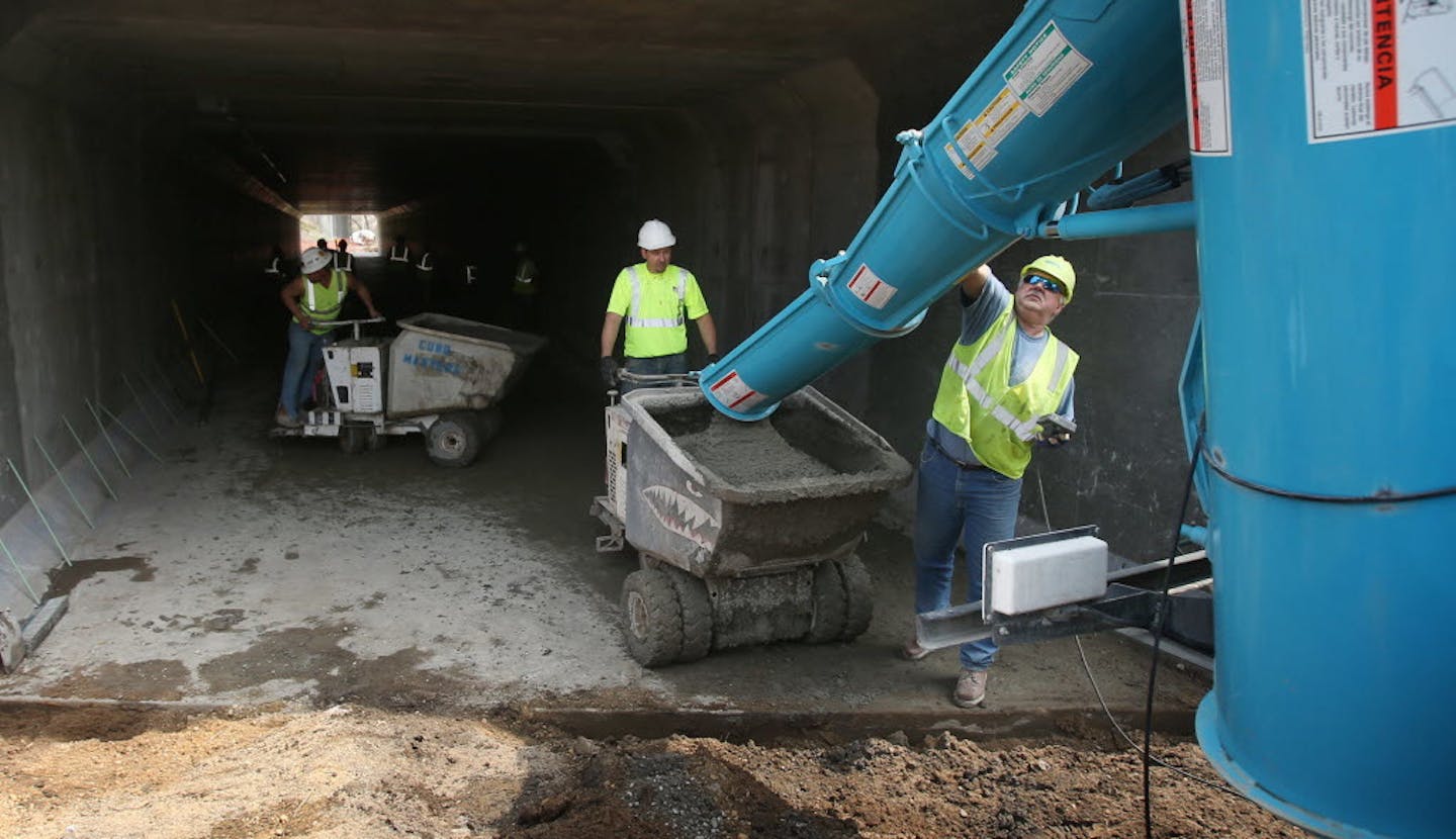 May 7, 2014: A Minneapolis inspector (left) looked on as workers poured concrete for the bike trail under 35W in Minneapolis.