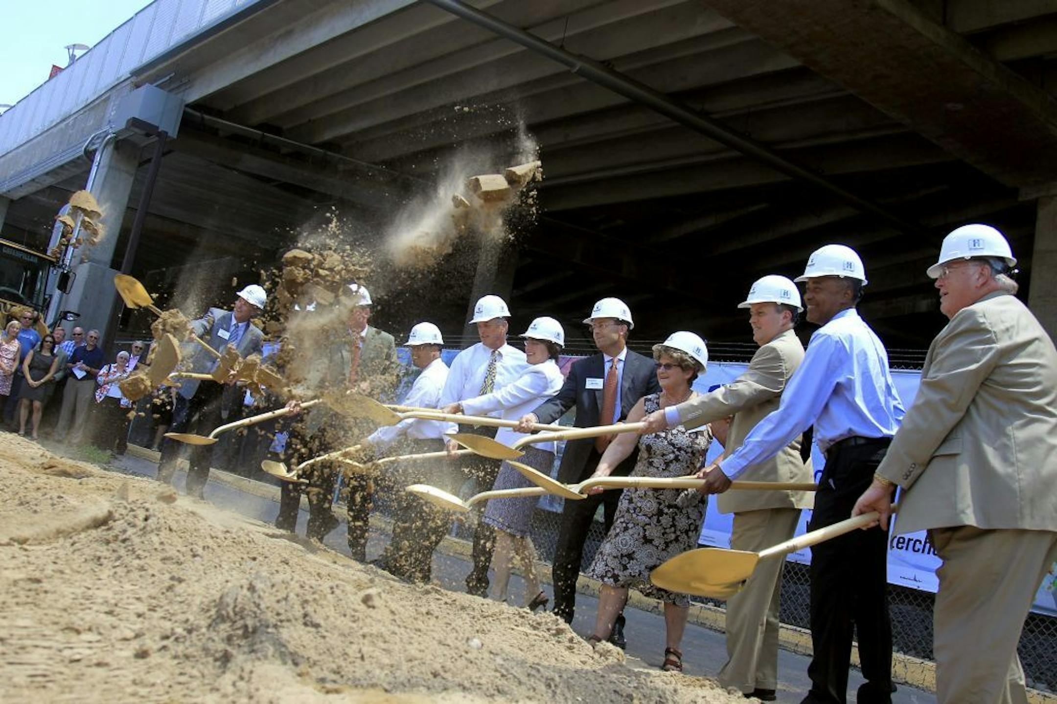 Minnesota leaders including Senator Amy Klobuchar, center, broke ground with gold shovels during groundbreaking ceremonies for the Interchange project, a transit hub that will serve light-rail, bus and commuter rail passengers near Target Field, Monday, July 9, 2012. (ELIZABETH FLORES/STAR TRIBUNE) ELIZABETH FLORES � eflores@startribune.com