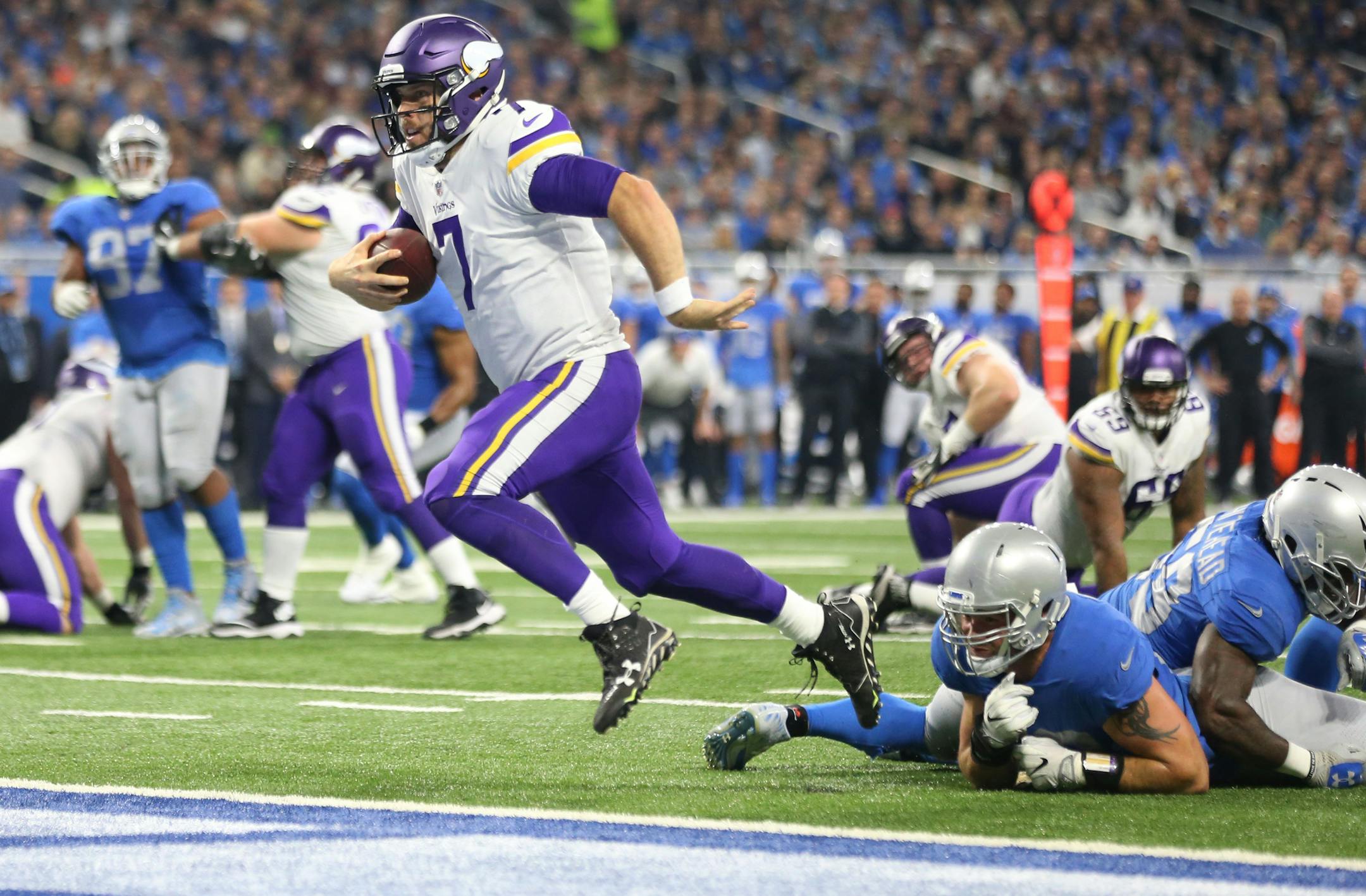 Minnesota Vikings quarterback Case Keenum (7) split two Lions defenders for a first quarter touchdown at Ford Field Thursday November 23, 2017 in Detroit , MI.