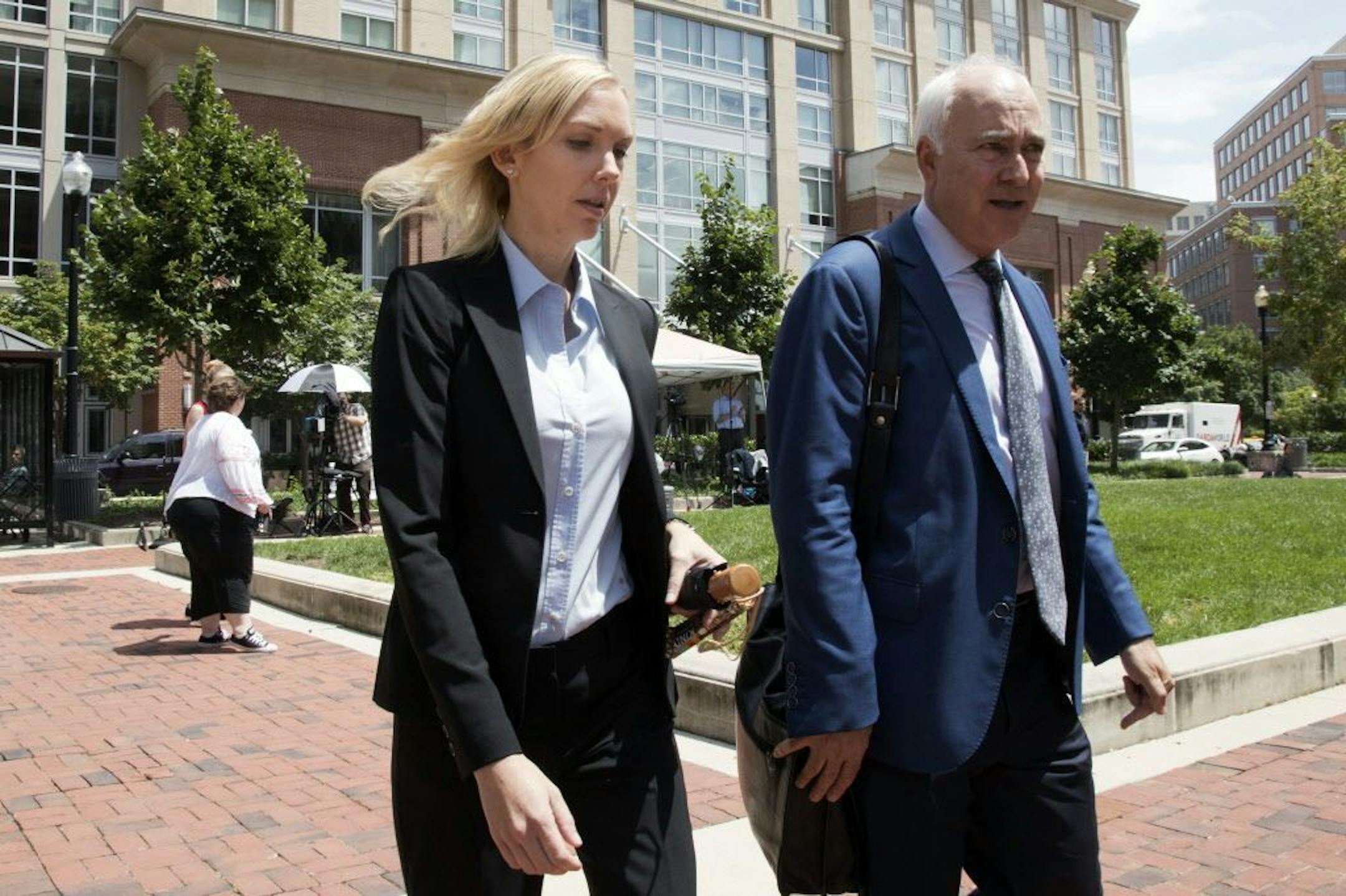 Paul Manafort's former bookkeeper Heather Washkuhn, left, walks to the Alexandria Federal Courthouse in Alexandria, Va., Thursday, Aug. 2, 2018, to testify at President Donald Trump's former campaign chairman's tax evasion and bank fraud trial. Washkuhn testified that Manafort kept her in the dark about the foreign bank accounts he was using to buy millions in luxury items and personal expenses.