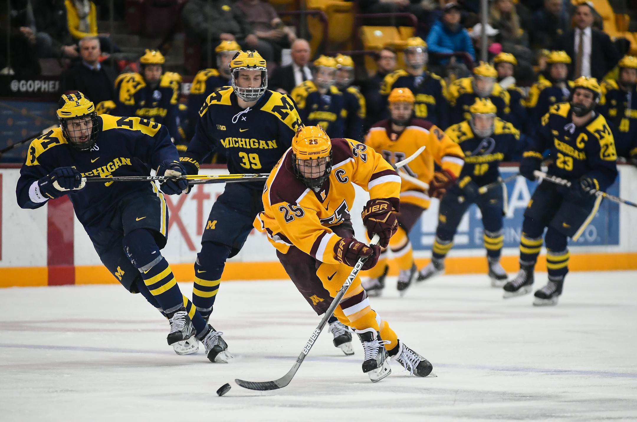 Gophers center Justin Kloos (25) raced down the ice with the puck during a second period breakaway against Michigan