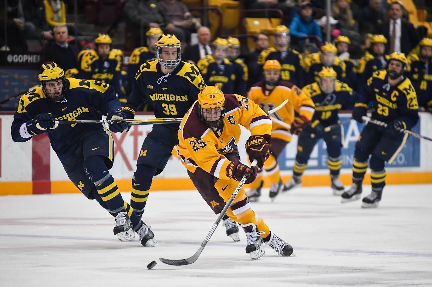 Gophers center Justin Kloos (25) raced down the ice with the puck during a second period breakaway against Michigan