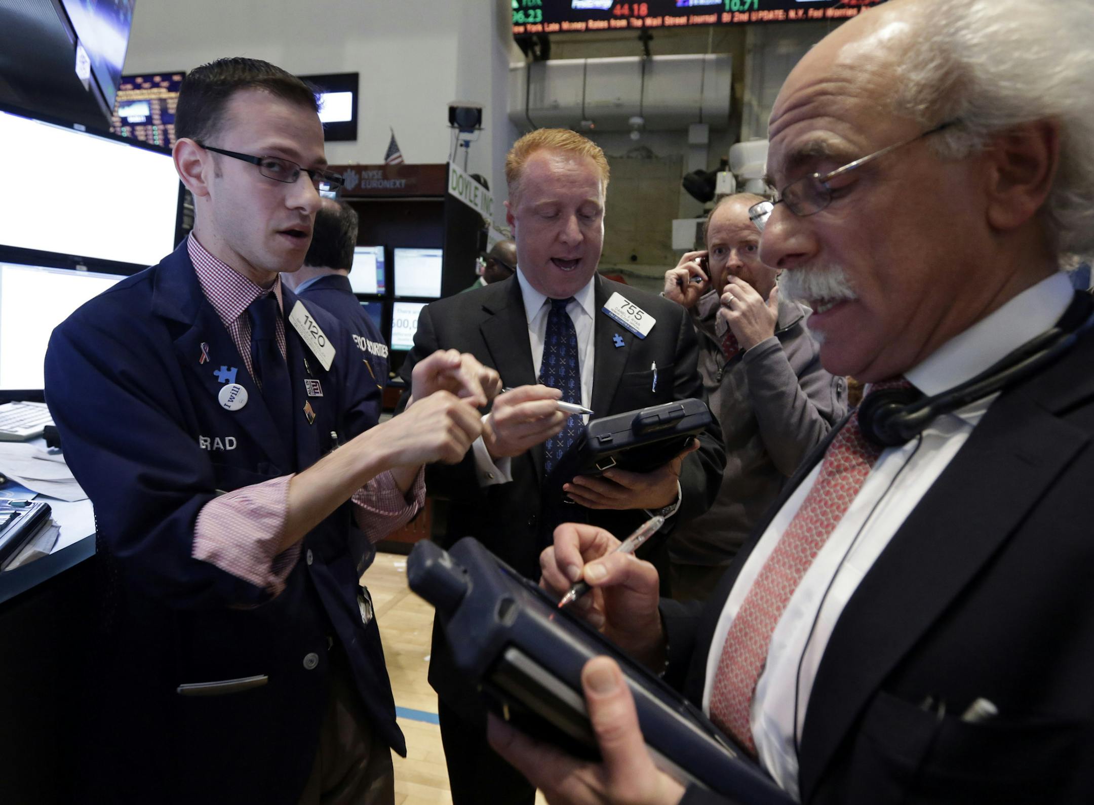 FILE - Specialist Bradley Kessler, left, works with traders on the floor of the New York Stock Exchange in this May 7, 2013 file photo. Financial markets were subdued Thursday May 16, 2013 despite encouraging growth figures out of Japan, as investors paused for breath a day after the main U.S. stock indexes struck record highs. (AP Photo/Richard Drew, File)