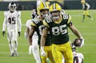 Green Bay Packers' Robert Tonyan (85) celebrates a touchdown reception with Malik Taylor (86) during the first half of an NFL football game against th