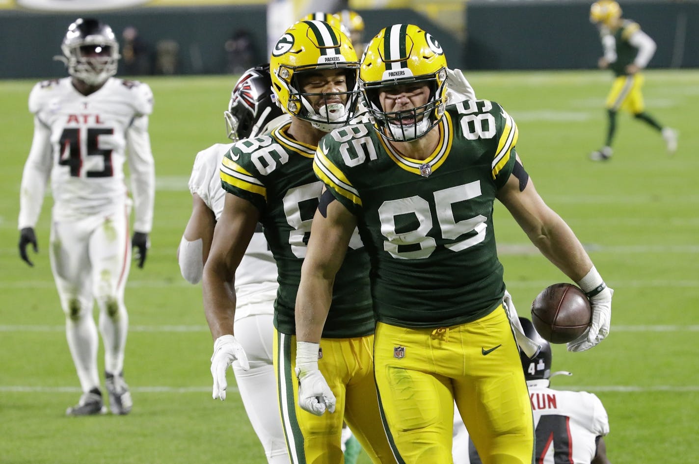 Green Bay Packers' Robert Tonyan (85) celebrates a touchdown reception with Malik Taylor (86) during the first half of an NFL football game against the Atlanta Falcons, Monday, Oct. 5, 2020, in Green Bay, Wis. (AP Photo/Mike Roemer)