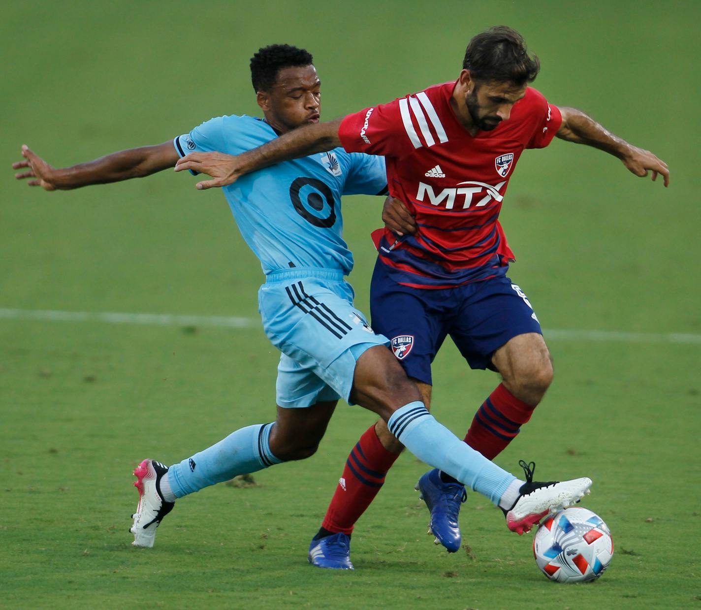 FC Dallas midfielder Facundo Quignon, right, tries to maintain ball control as Minnesota United midfielder Jacon Hayes defends during the first half of an MLS soccer match in Frisco, Texas, Saturday, June 19, 2021. (Steve Hamm/The Dallas Morning News via AP)