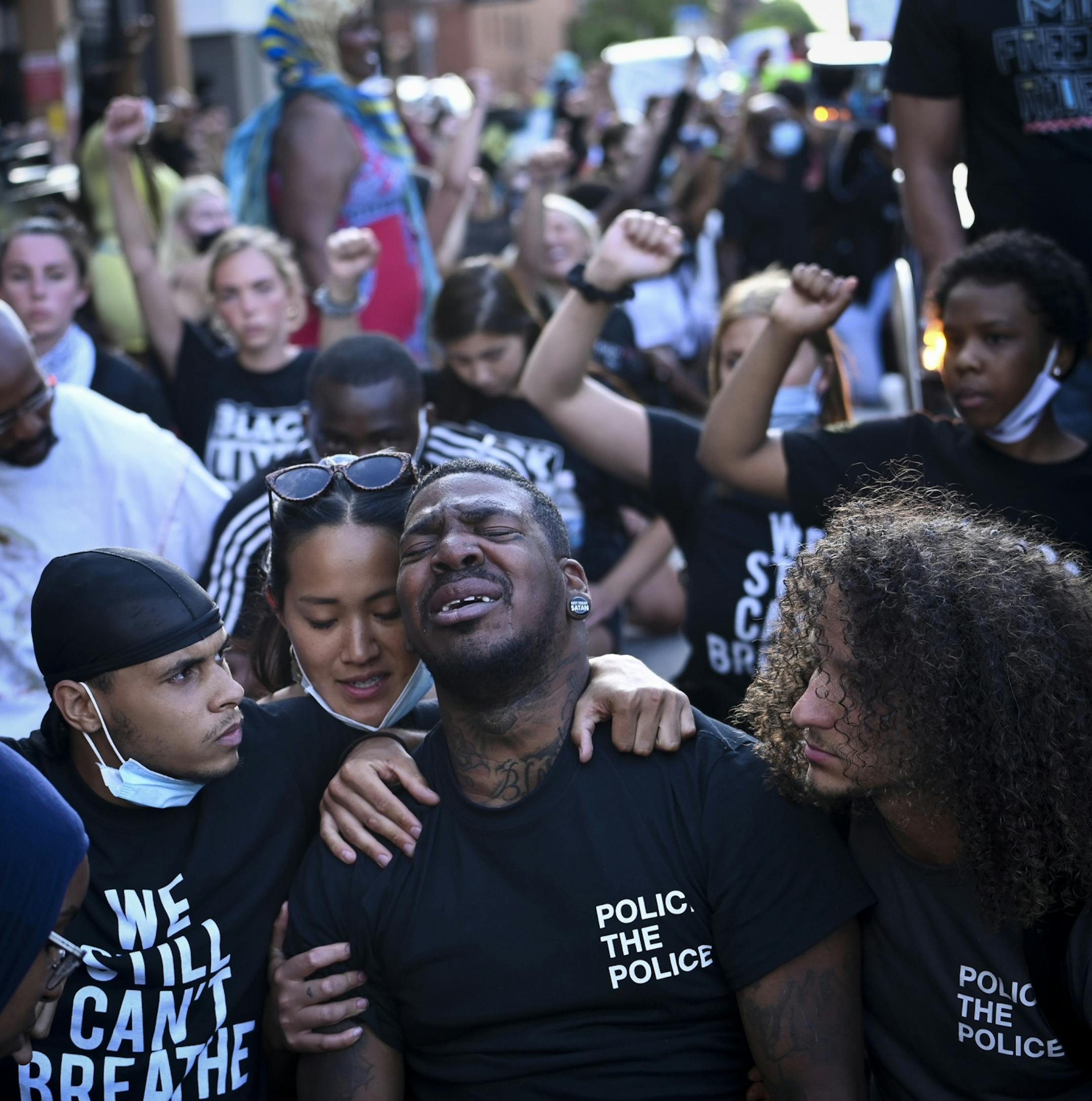 Tony Clark, one of the organizers of Saturday night's protest, was comforted by friends and fellow protesters as he was overcome with emotion during the march.