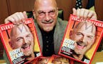 Minnesota Governor-elect Jesse Ventura poses with copies of Time magazine bearing his photo in his State Capitol transition office Tuesday, Nov. 10, 1