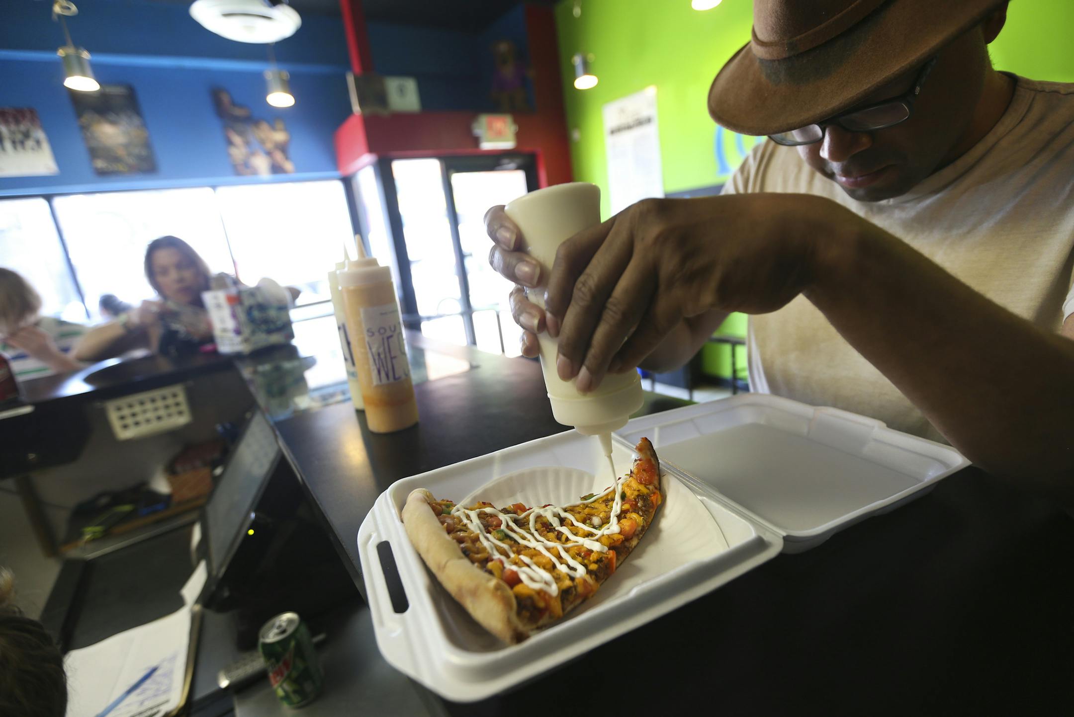 William Murphy squeezed some sour cream on a slice of taco pizza to go that came in a foam container at Mesa Pizza in Minneapolis. The containers will be banned by next spring.