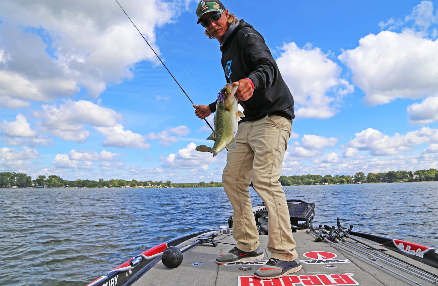 Seth Feider with a plump largemouth bass caught while practice fishing on Lake Minnetonka in advance of the big Bassmaster tournament on Lake Mille Lacs.