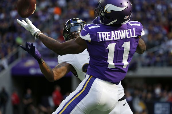 Baltimore Ravens cornerback Brandon Carr, rear, intercepts a pass intended for Minnesota Vikings wide receiver Laquon Treadwell (11) during the first 