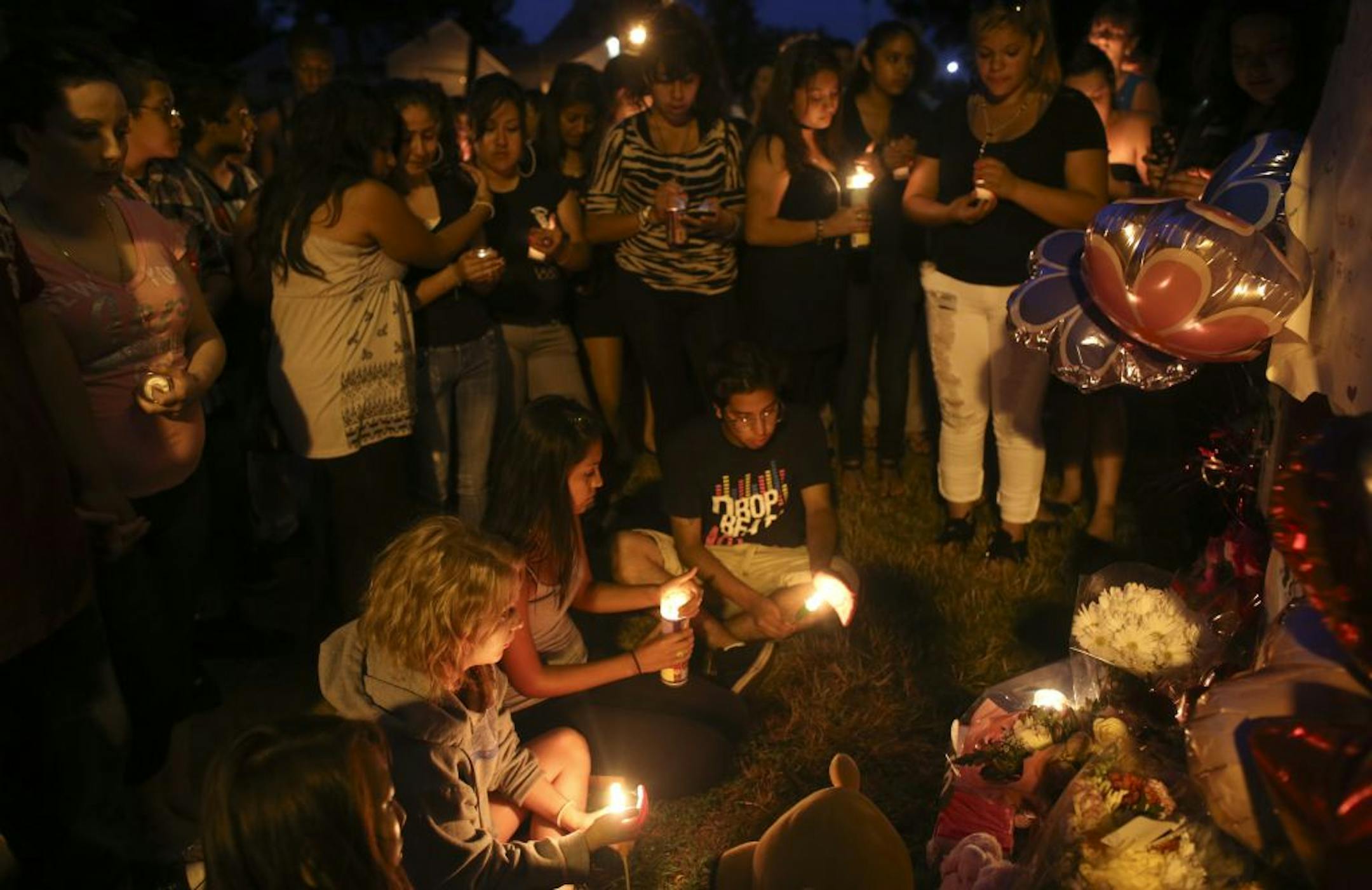 Fellow students and friends lit candles as they gathered together to sing to their friend Clarisse Grime who died after being struck by an SUV waiting for the bus in St. Paul, Min., Friday, July 6, 2012.