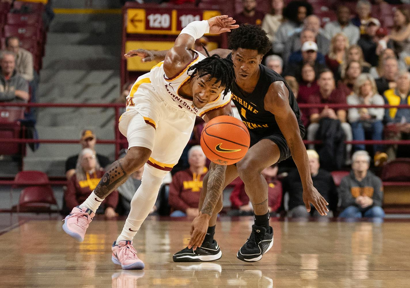 Elijah Hawkins (0) of the Minnesota is fouled by Zion Harmon (1) of Bethune-Cookman in the first half.