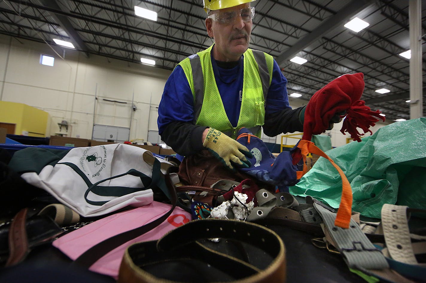 Recycling processor Travis Austin sorted items at the Goodwill Outlet in Brooklyn Park. Charities are no longer choosy about what can be donated.