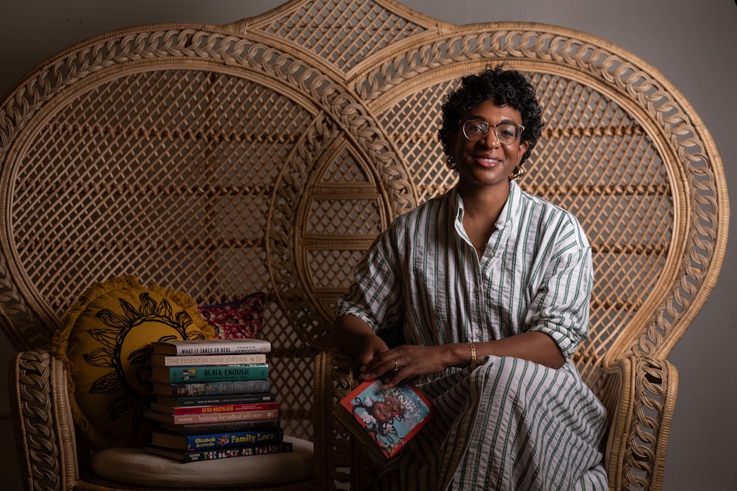 Nicole Nfonoyim-Hara sits in a wicker chair on June 20 inside the bookstore and gallery she is launching in Rochester.