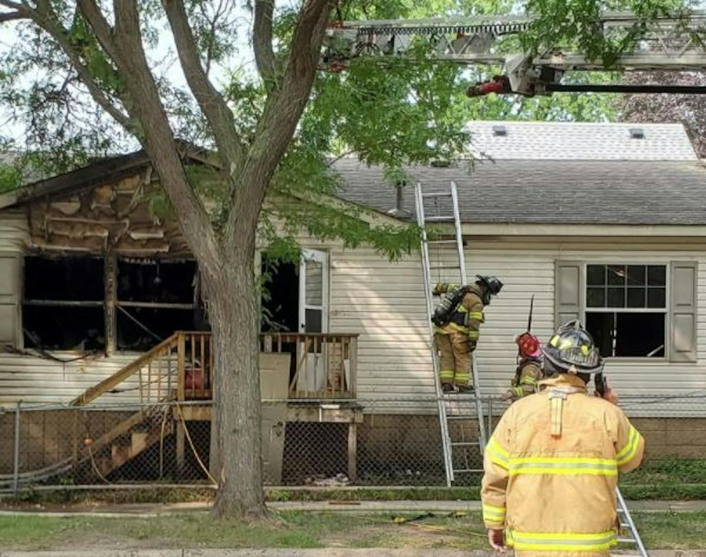 Firefighters at the scene of a blaze where a man was shot to death the previous day.