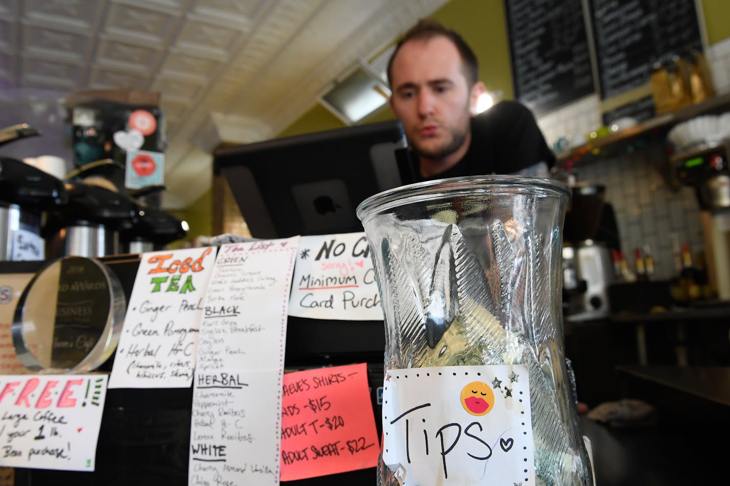 Andy Regan, a barista at Maeve's Cafe in Northeast Minneapolis, changed the music at the cafe between orders Wednesday afternoon. ] AARON LAVINSKY &#xef; aaron.lavinsky@startribune.com Restaurants owners are preparing to make their last stand against a Minneapolis minimum wage that doesn't count tips as wages. We photograph Maeve's Cafe on Wednesday, May 24, 2017 in Minneapolis, Minn.