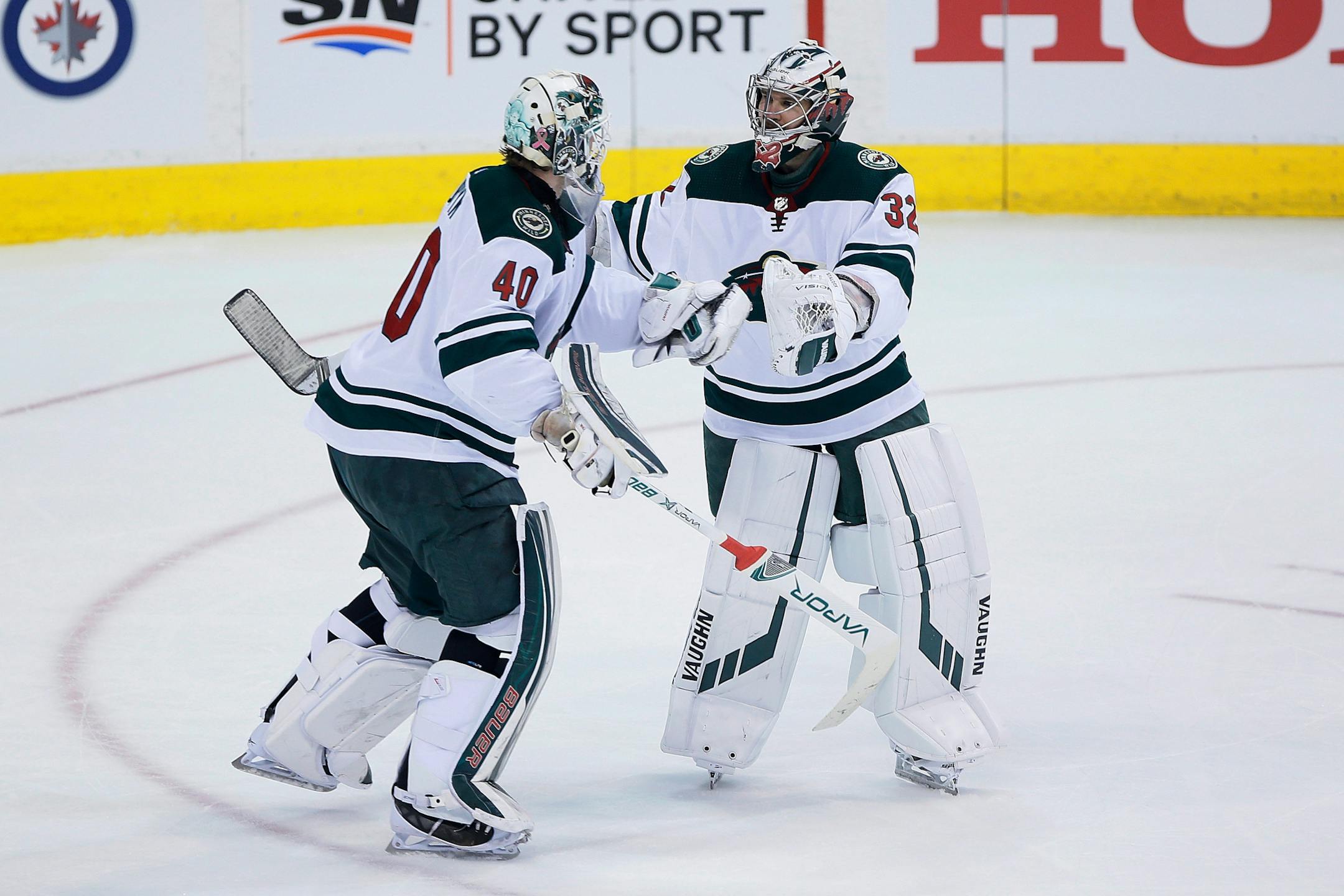 Minnesota Wild goaltender Devan Dubnyk (40) is replaced by goaltender Alex Stalock (32) during first period against the Winnipeg Jets in Game 5 of an NHL hockey first-round playoff series in Winnipeg, Manitoba, Friday, April 20, 2018.