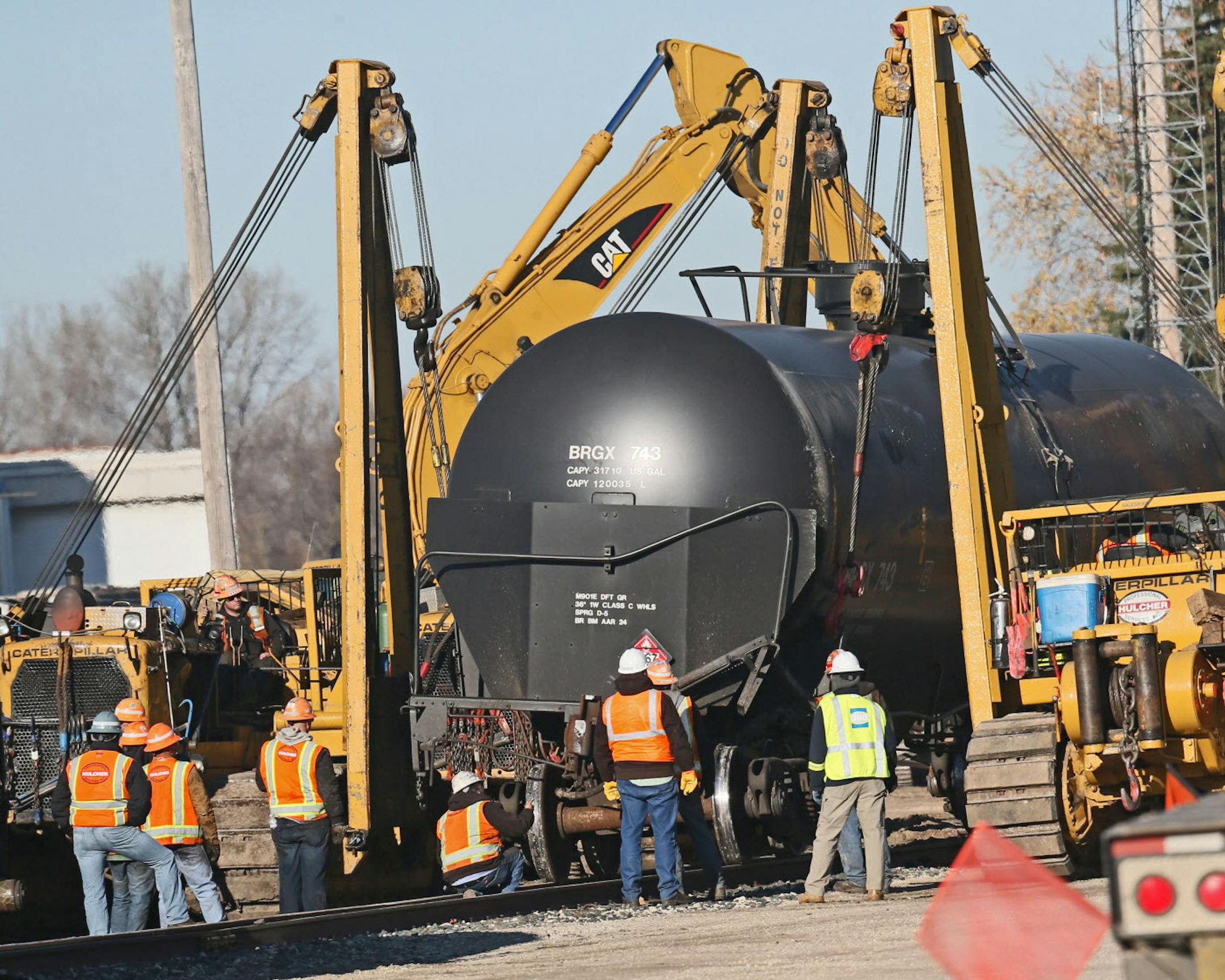 Crews repair track and clean up the site of a train derailment which spilled hundreds of gallons of crude oil in Watertown, Wis., Monday, Nov. 9, 2015. Residents who evacuated dozens of homes in Watertown following the derailment Sunday afternoon were still being kept away Monday as 12 derailed cars were moved to a temporary track. Thirteen of the train's 110 cars derailed, and 109 of them were carrying crude oil, officials said. (Michael Sears/Milwaukee Journal-Sentinel via AP) MANDATORY CREDIT