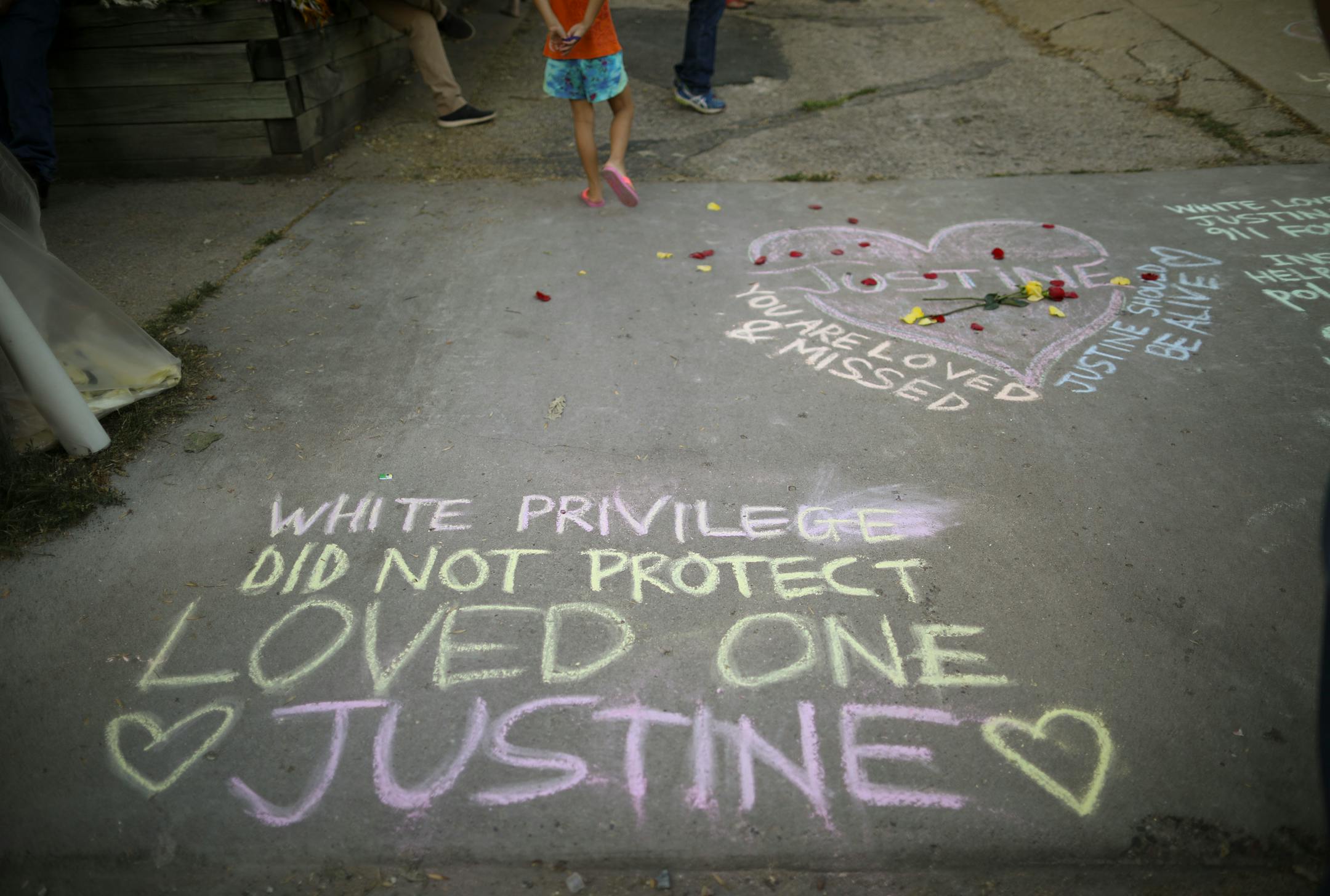 Chalk drawings and messages Sunday evening at the entrance to the alley near where Justine Damond was shot and killed.