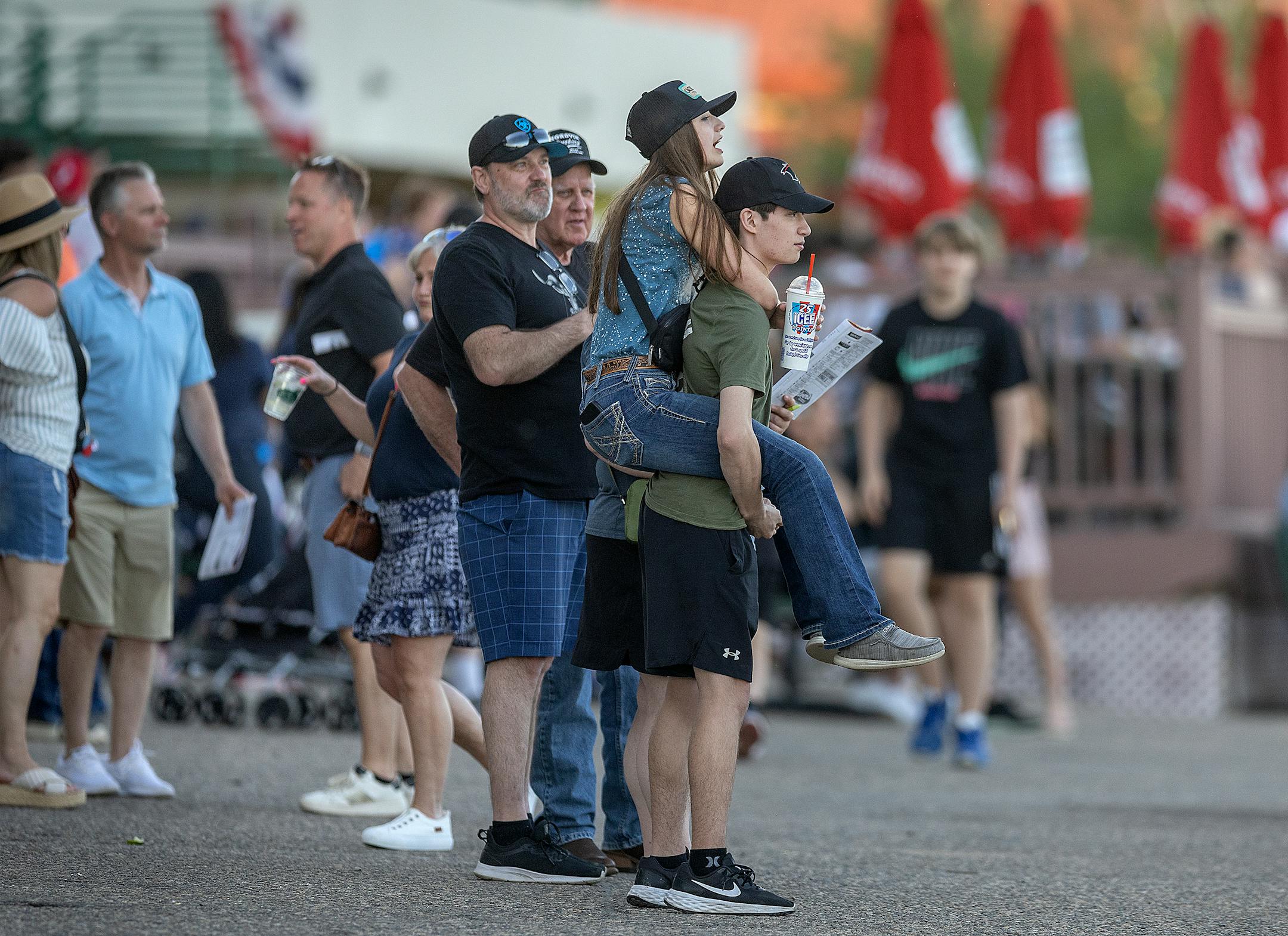 McKenzie Buetow-Smith gets a lift form her boyfriend Connor Hudson as they watch races on opening night at Canterbury Park.